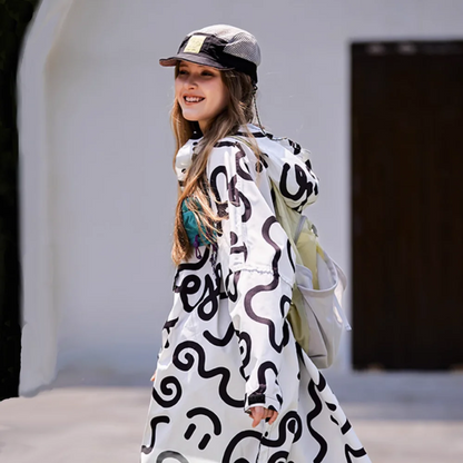 Heller Regenponcho mit Kapuze an junger Frau