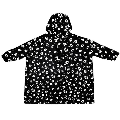 Weiter großer Regenponcho mit Kapuze schwarz weiß mit Leoparden Muster, reflektiert in der Dunkelheit